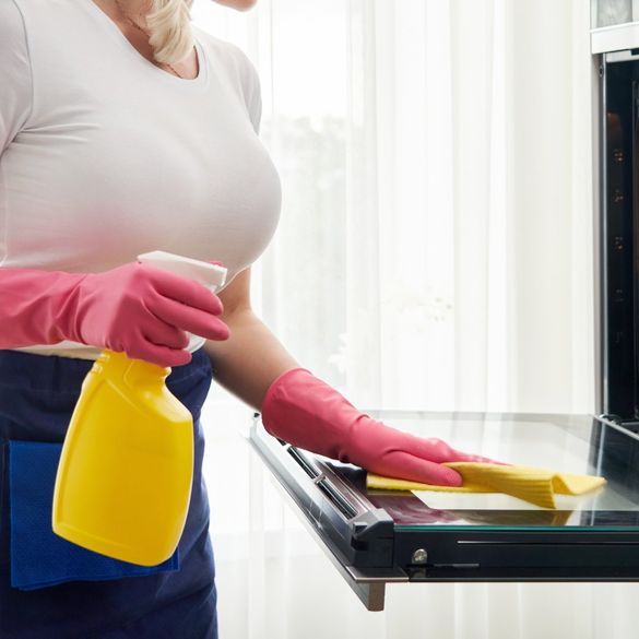 Mujer limpiando horno